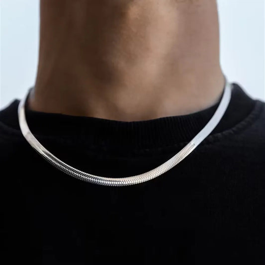 Close-up of a stainless steel hip hop necklace worn around the neck with a black shirt