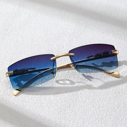 Chic rimless square glasses with blue gradient lenses and gold metal temples on textured white surface