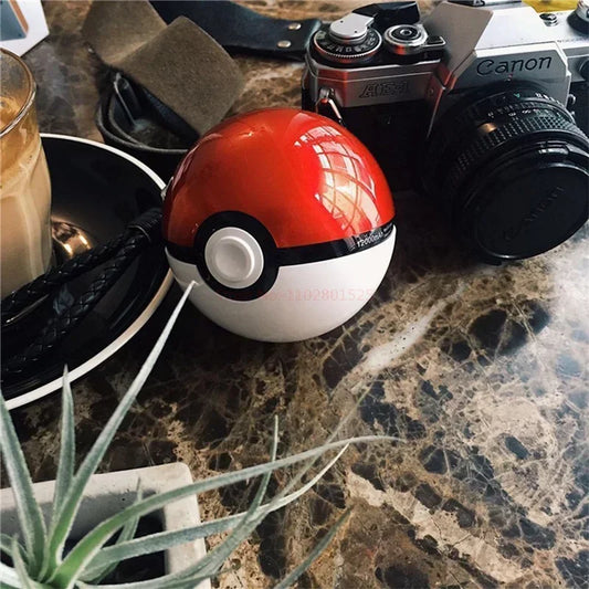 LIVSY Pokeball power bank on a marble table next to a Canon camera and a glass of coffee