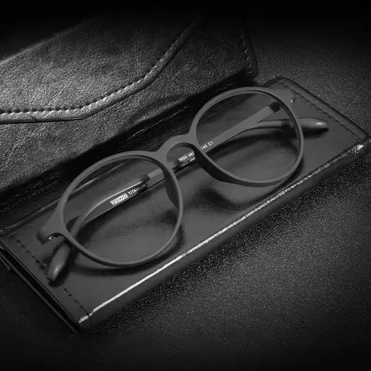 StorePilot retro blue light glasses with round black frames resting on a black leather case