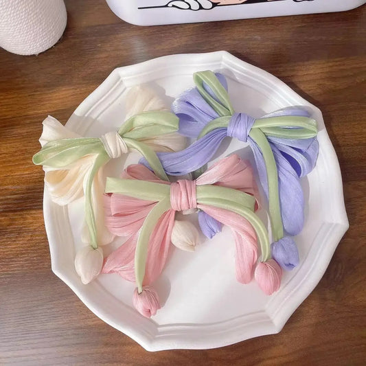 LIVSY vintage floral bow hair clip set in pastel colors displayed on a white plate